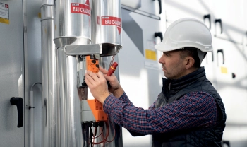 Service Techniker mit Helm und Weste wartet 3-Wege-Ventil Motor