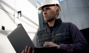 Service Techniker mit Helm mit Laptop in der Hand