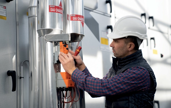 Service Techniker mit Helm und Weste wartet 3-Wege-Ventil Motor