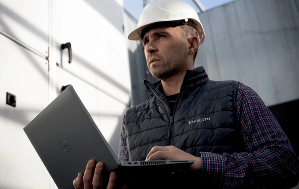 Service Techniker mit Helm mit Laptop in der Hand