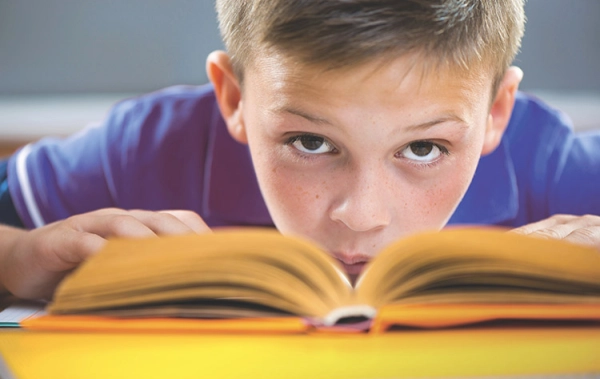 Schulkind mit aufgeschlagenem Buch